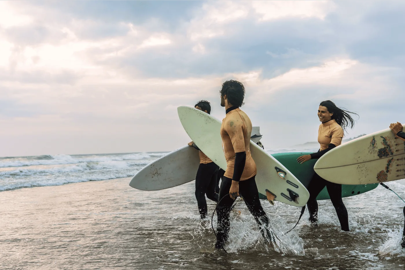 Surf students walking into the sea with their boards
