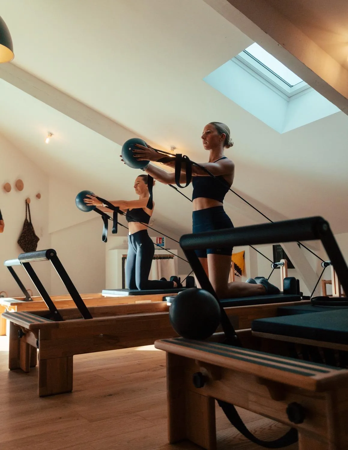 A student on a Pilates reformer in a studio